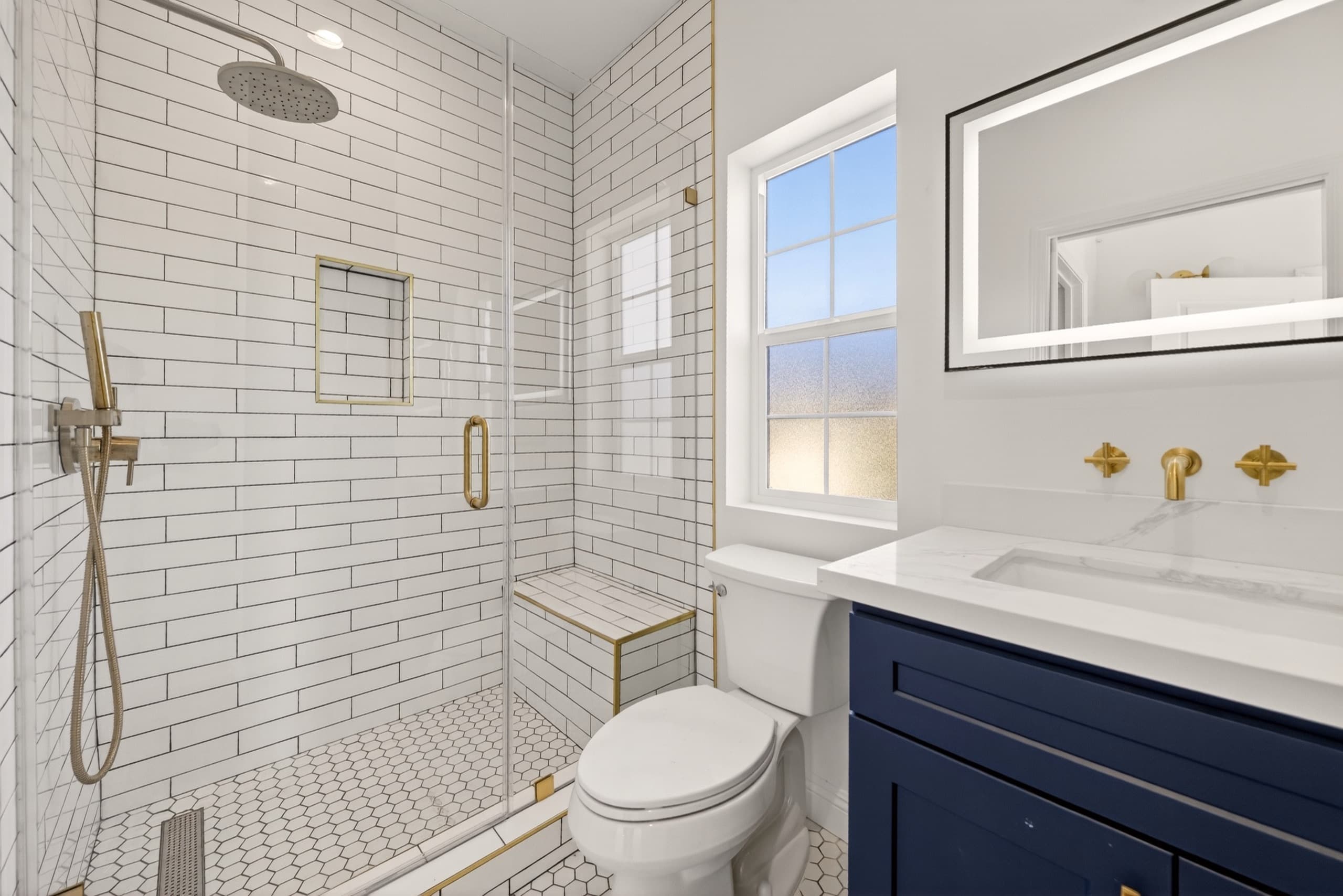 ADU bathroom with subway tile and brass fixtures
